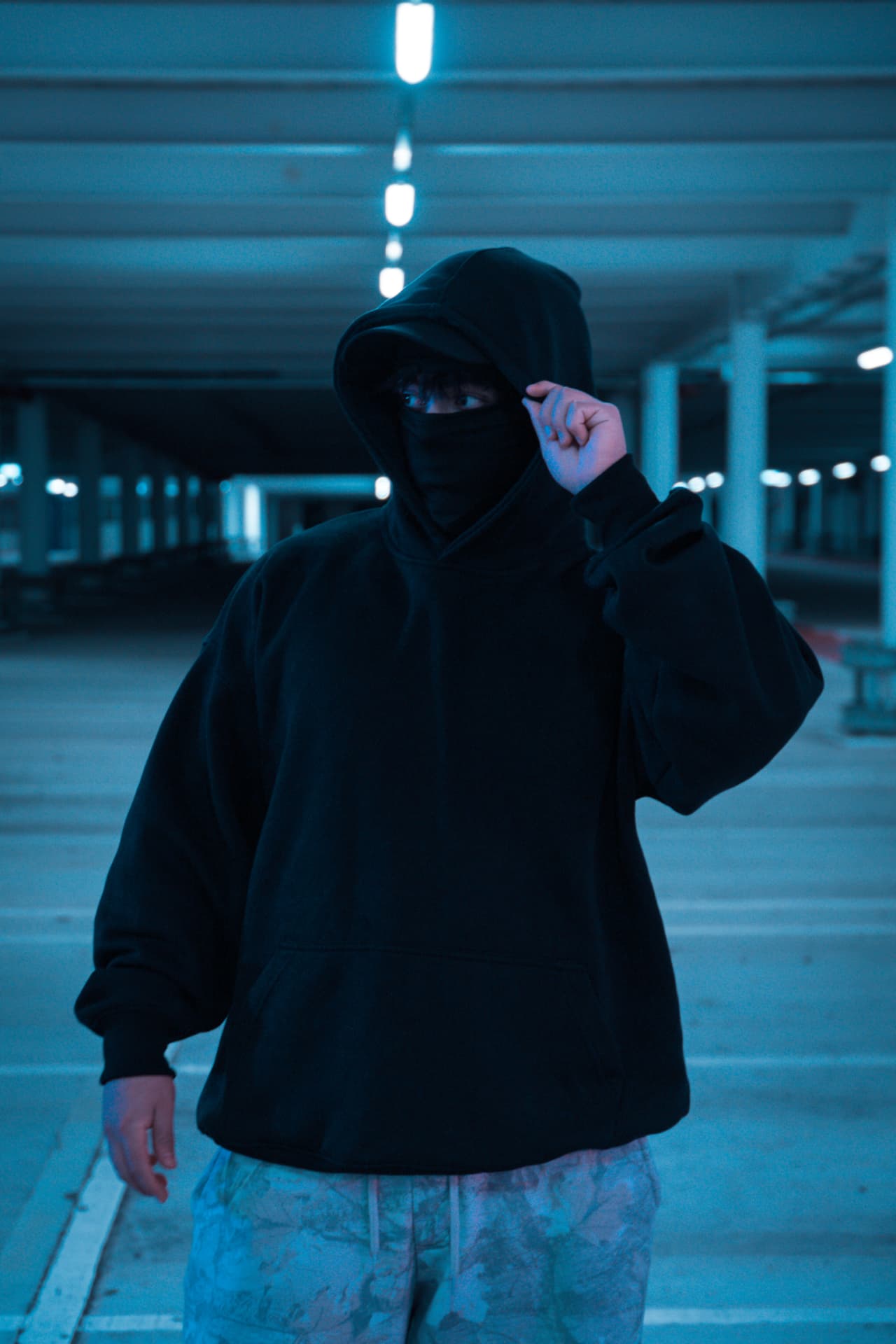 Model wearing black Sakura Dragon hoodie, front view in urban garage setting